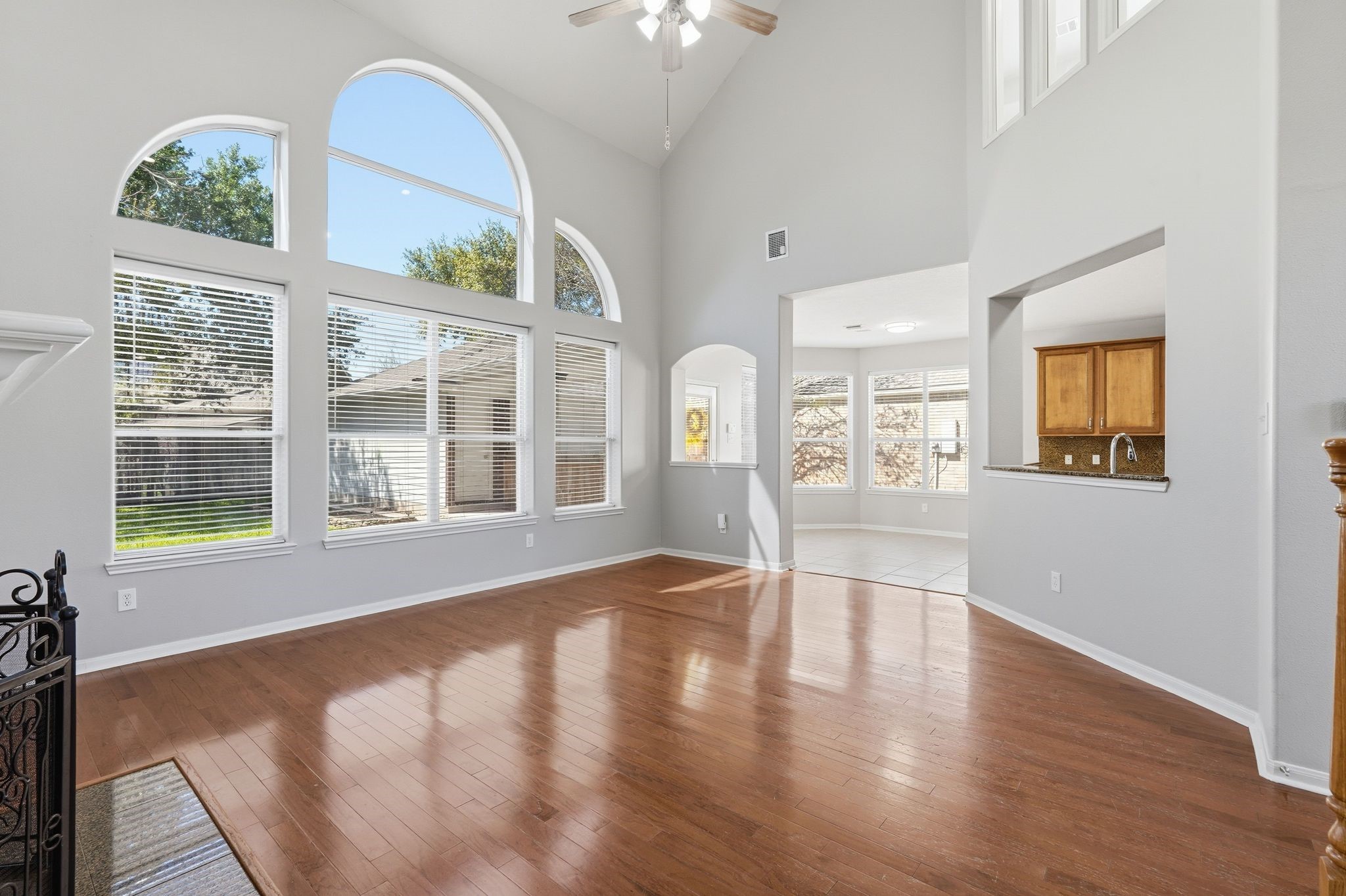 24931 Corbin Gate Drive Spring, TX 77389 - Photo 14 of 50 This spacious living area features high ceilings and large arched windows that let in plenty of natural light. The open layout seamlessly connects to the dining area and kitchen, creating a bright and inviting atmosphere.
