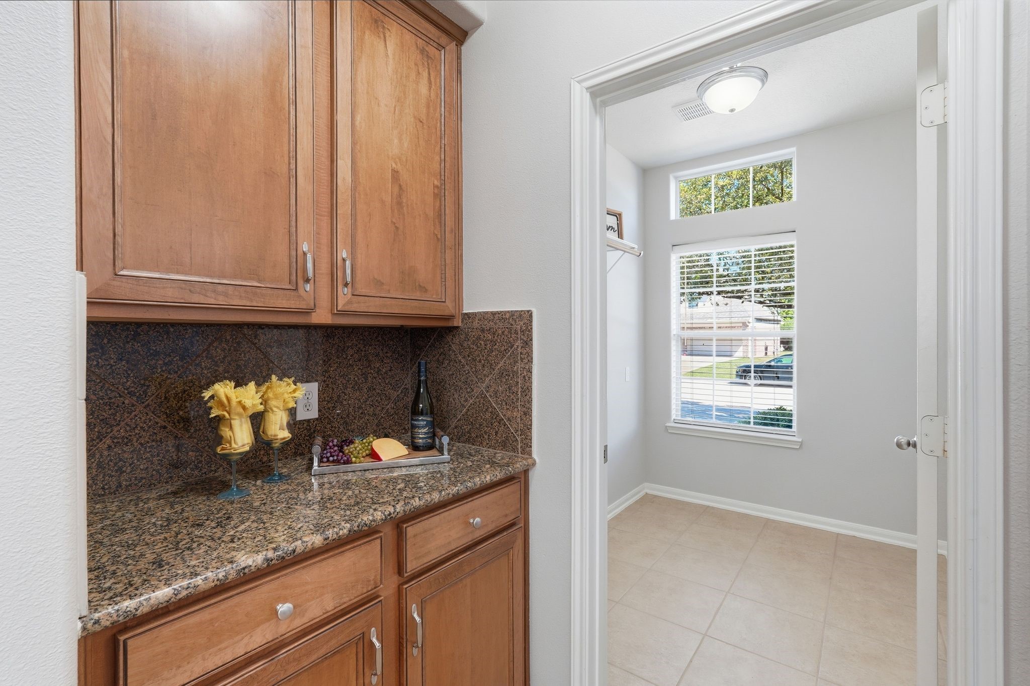 24931 Corbin Gate Drive Spring, TX 77389 - Photo 22 of 50 This butlers pantry provides a cozy nook with wooden cabinets and a granite countertop, leading into the laundry room.