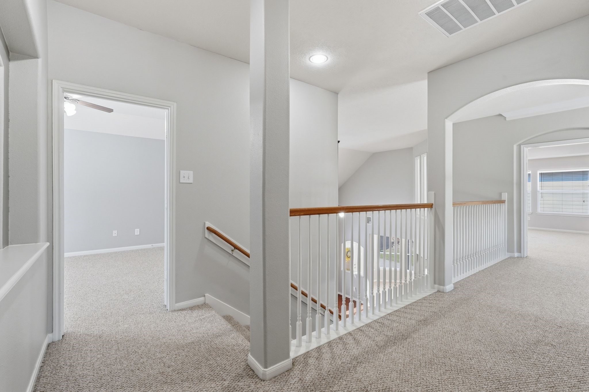 24931 Corbin Gate Drive Spring, TX 77389 - Photo 25 of 50 This hallway features neutral walls, featuring a staircase with white railing and wooden handrails. It leads to multiple rooms with large windows and a game room creating an open and airy feel.