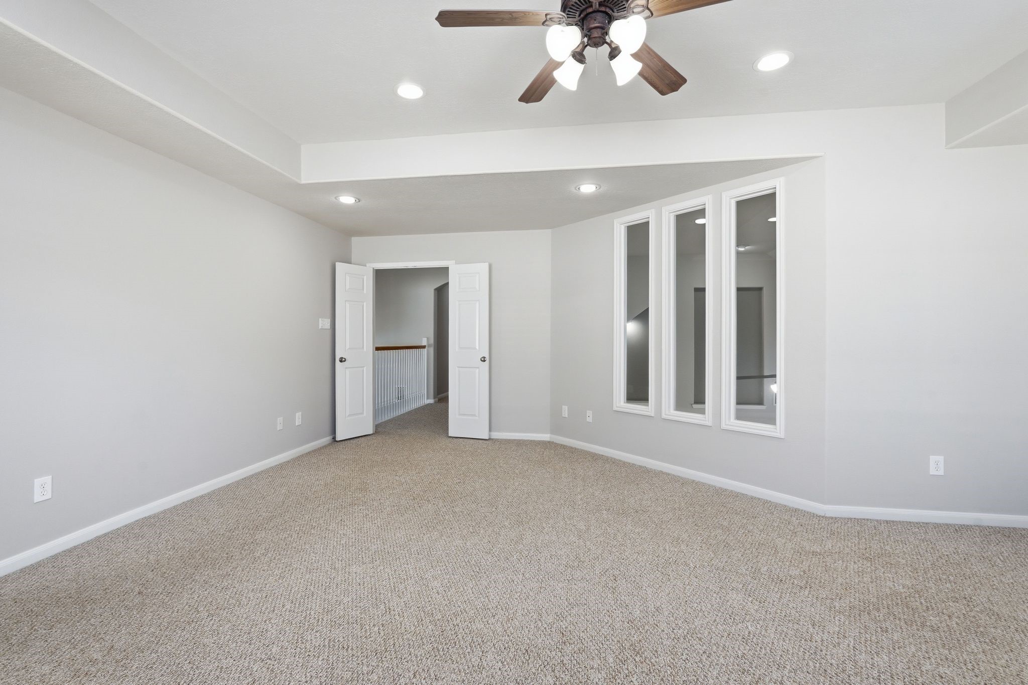24931 Corbin Gate Drive Spring, TX 77389 - Photo 30 of 50 This spacious room features neutral carpeting, recessed lighting, and a ceiling fan. It includes white trim and three vertical windows, with double doors offering an open and airy feel.