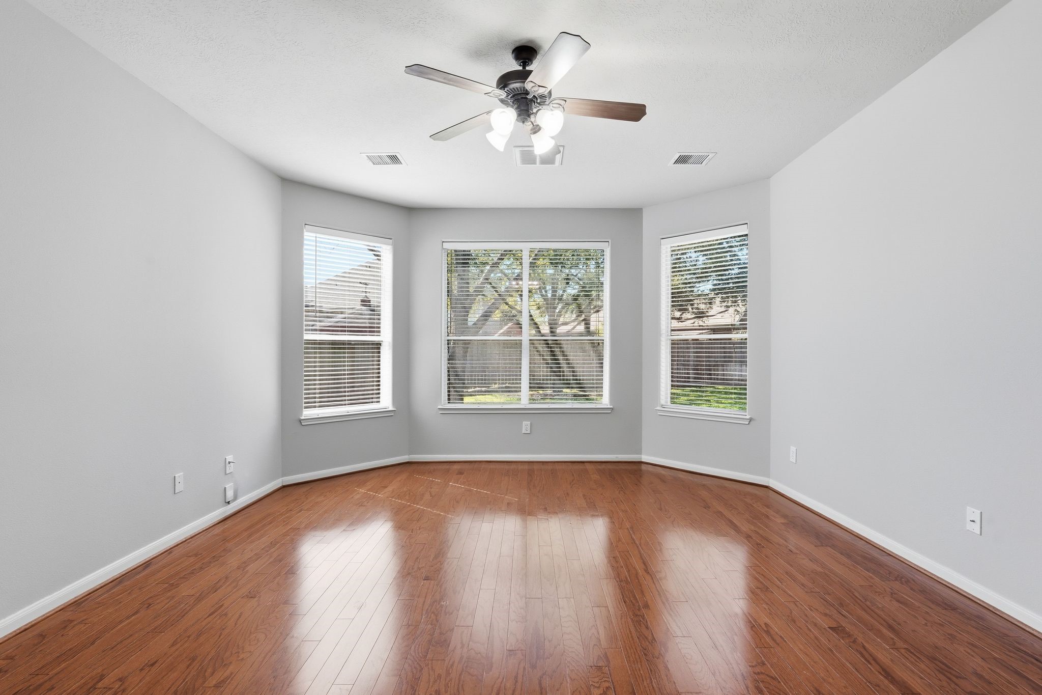 24931 Corbin Gate Drive Spring, TX 77389 - Photo 33 of 50 This spacious and bright primary bedroom features hardwood floors, a ceiling fan, and large windows that offer plenty of natural light and a view of the private backyard.