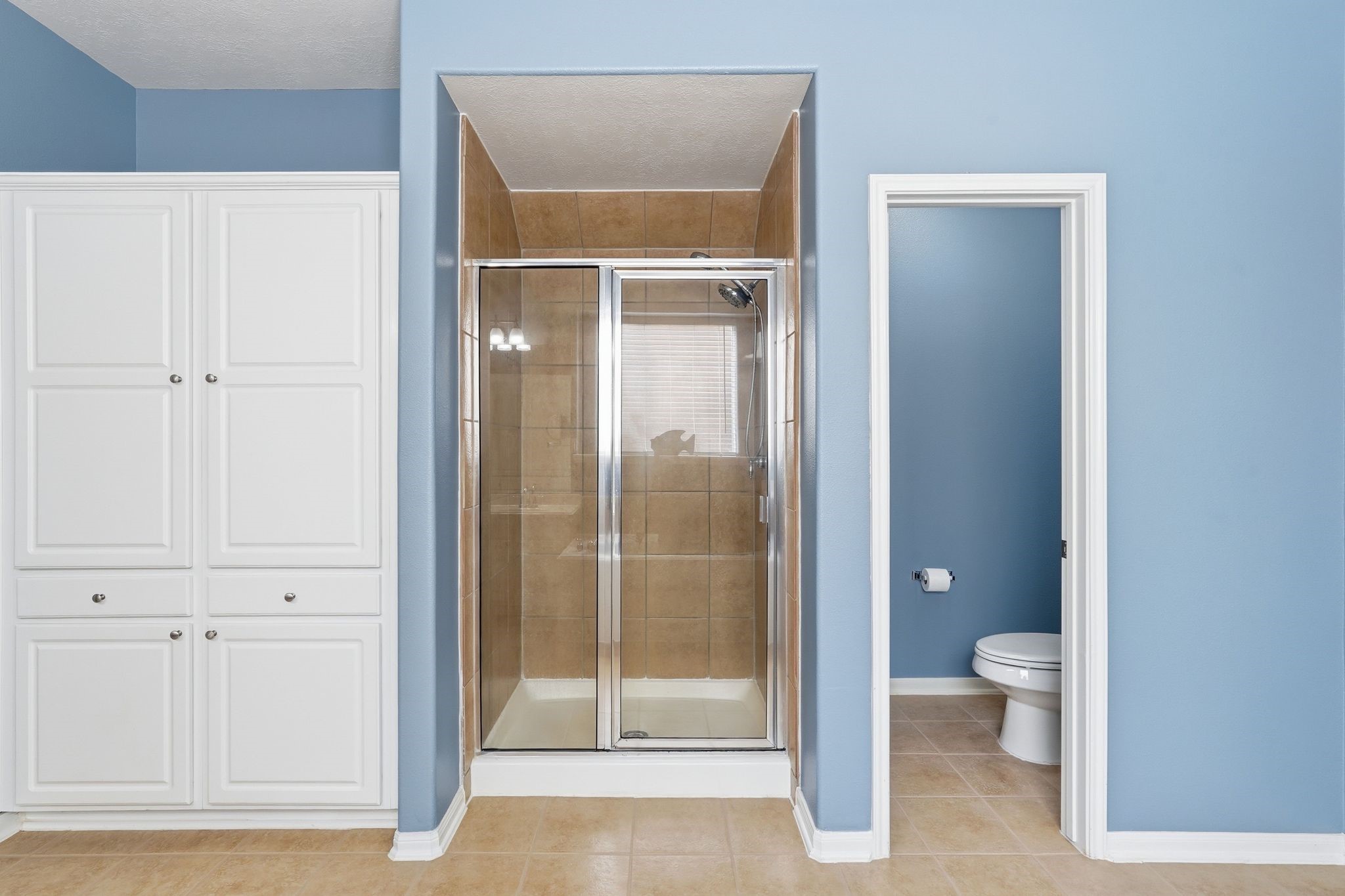 24931 Corbin Gate Drive Spring, TX 77389 - Photo 37 of 50 This primary bathroom features a walk in shower with glass doors and built-in white storage cabinets.