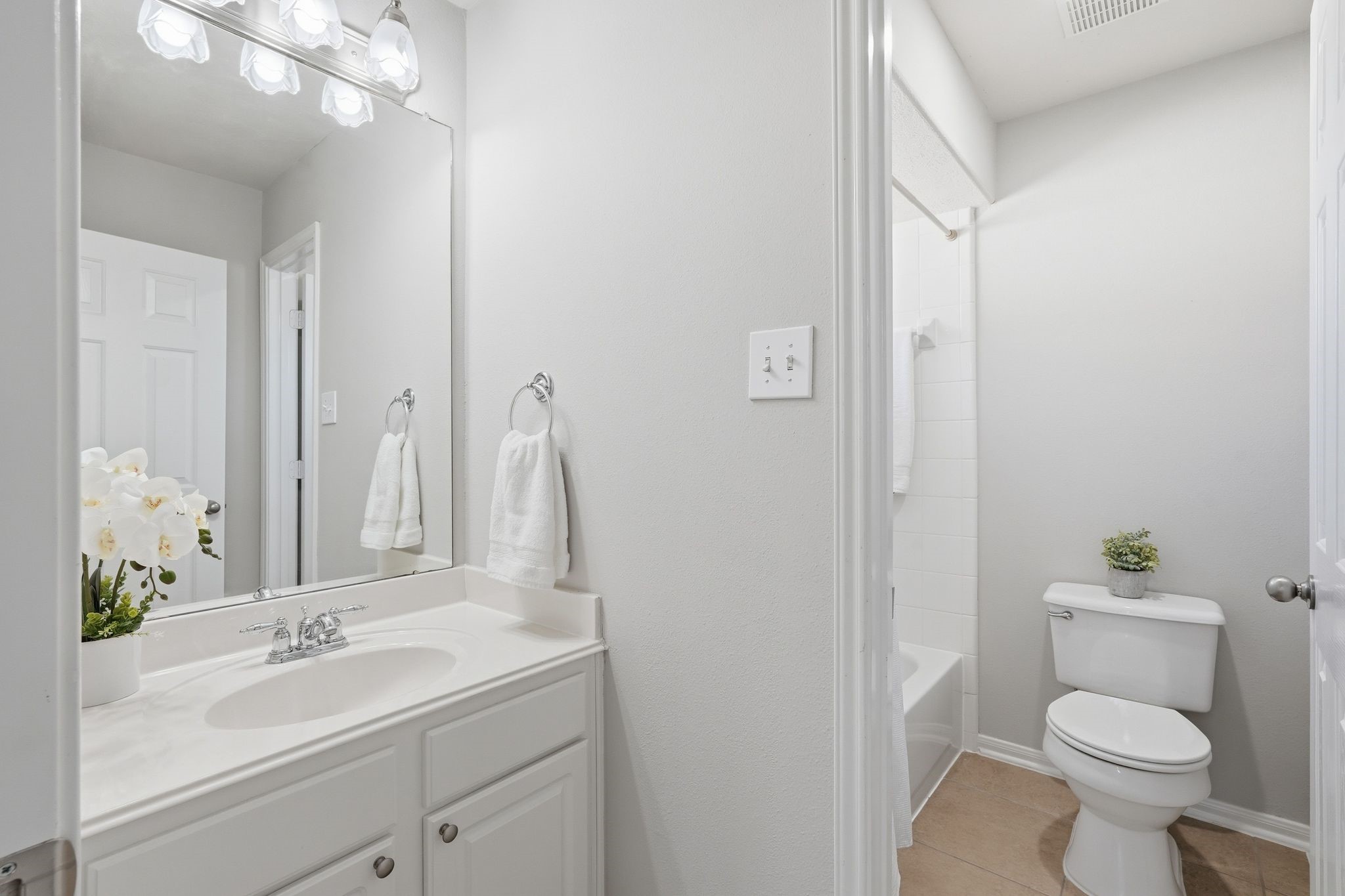 24931 Corbin Gate Drive Spring, TX 77389 - Photo 45 of 50 Bright and clean bathroom with white cabinetry, a large mirror, and modern lighting.
