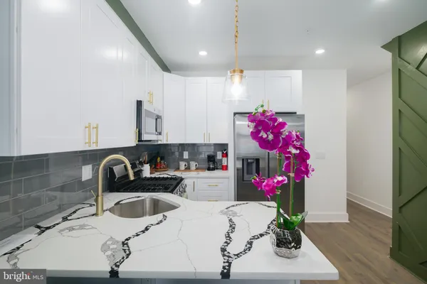 a kitchen with a sink a refrigerator and cabinets