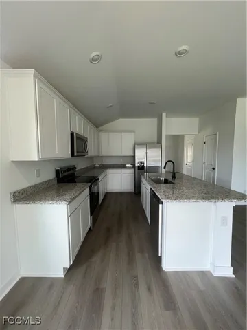 a kitchen with stainless steel appliances granite countertop a stove a sink and a refrigerator