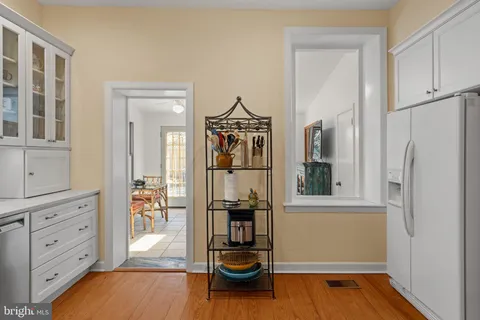 a bedroom with a bed a dresser and painting on the wall