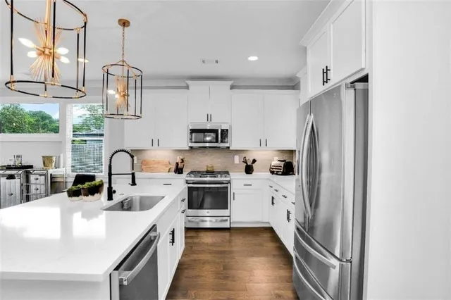 a kitchen with stainless steel appliances a refrigerator sink and cabinets