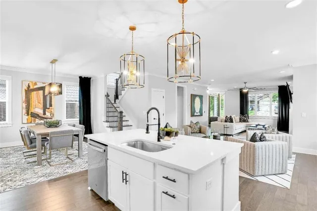 a kitchen with stainless steel appliances a sink a counter space and living room view