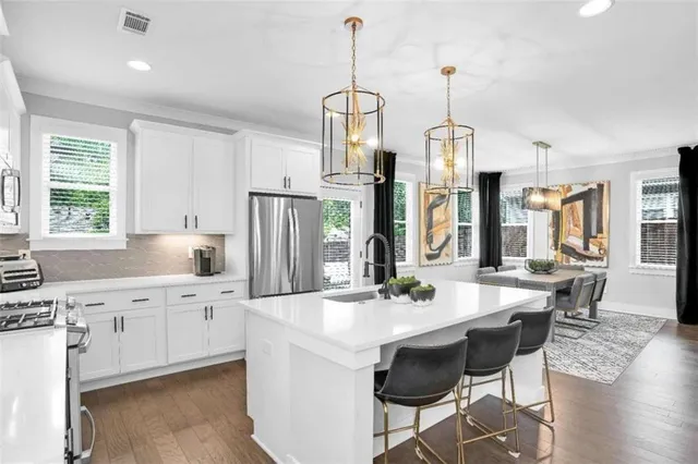 a kitchen with stainless steel appliances a sink stove and refrigerator