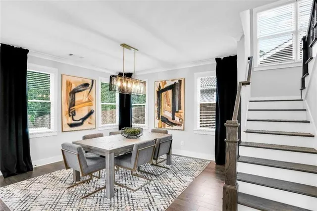 a dining room with wooden floor a chandelier a wooden table and chairs