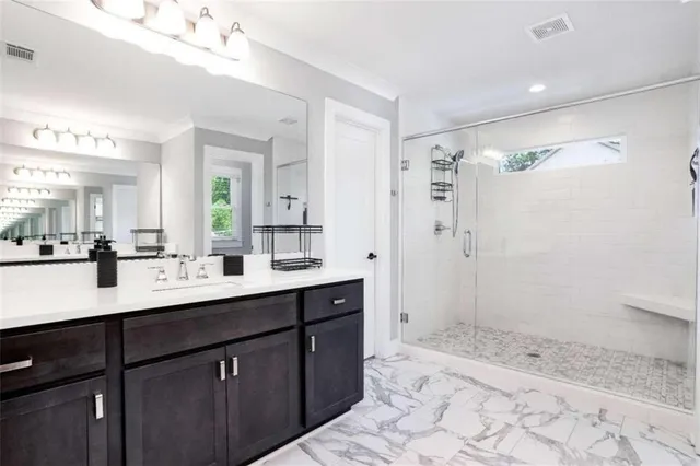 a spacious bathroom with a shower sink and mirror