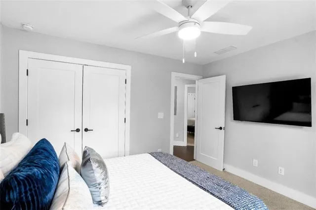 a spacious bedroom with a bed and a flat screen tv