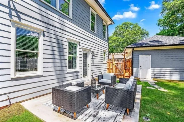 a view of a house with backyard and sitting area