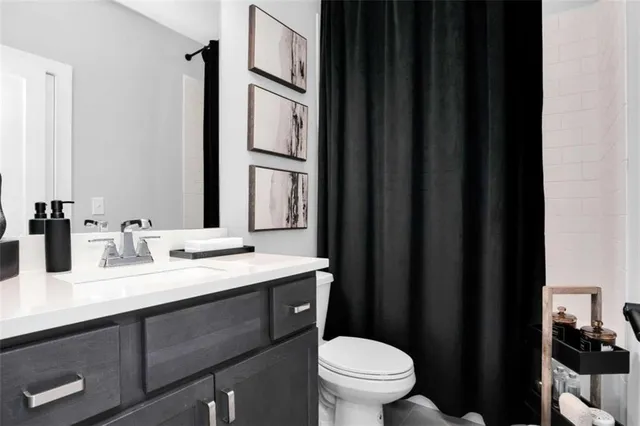 a bathroom with a sink a toilet a mirror and vanity