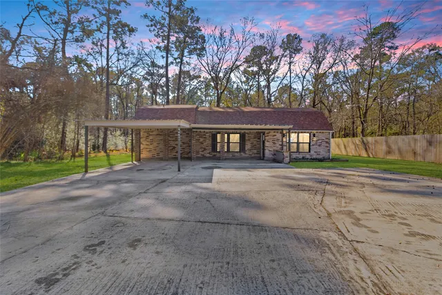 a front view of a house with a yard and trees
