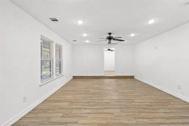 wooden floor in an empty room with a window