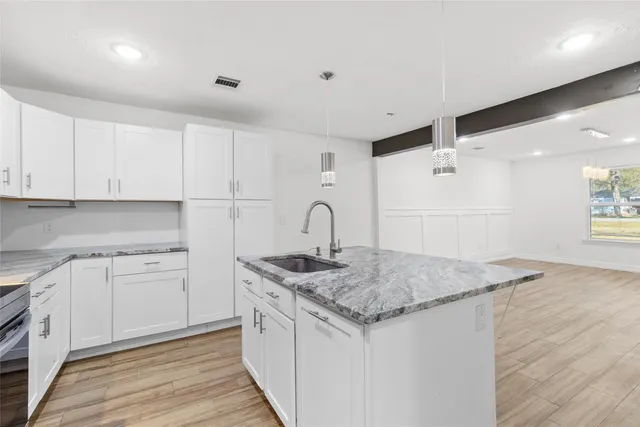 a kitchen with white cabinets appliances and sink