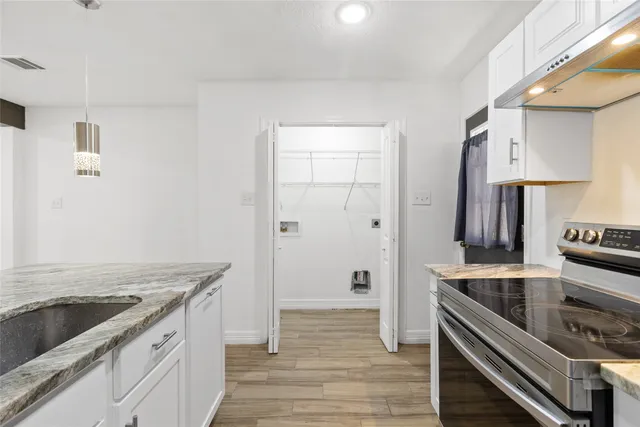 a kitchen with a stove and a wooden floor
