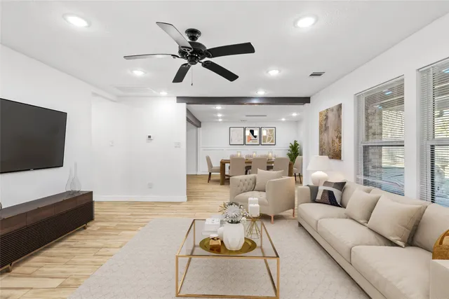 a living room with furniture and a flat screen tv with wooden floor