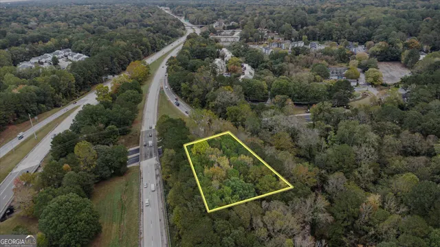 an aerial view of a residential houses with outdoor space and trees