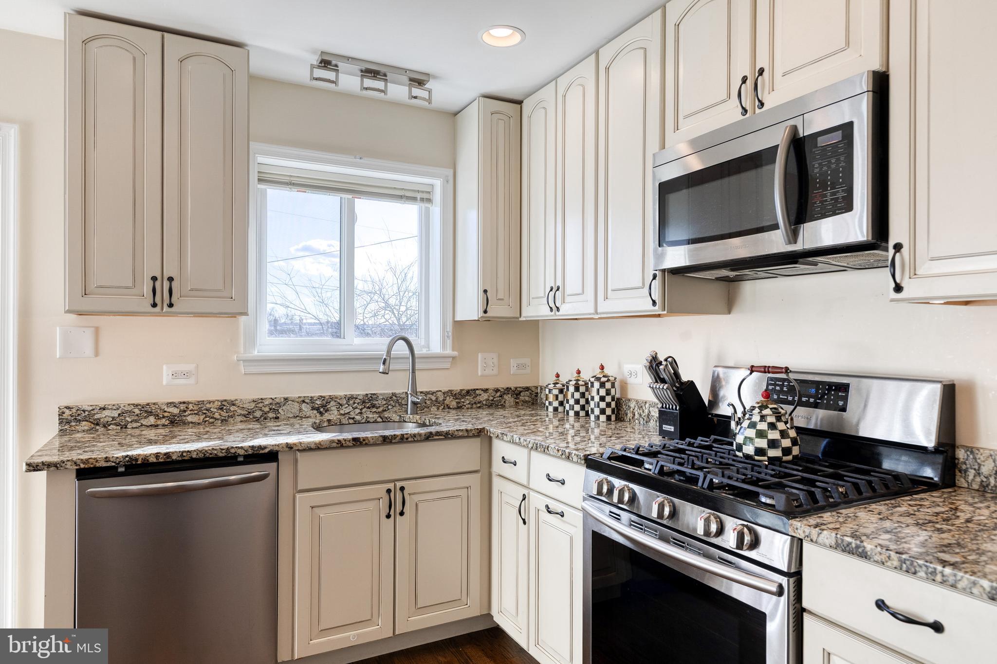 1205 Roland Heights Avenue Baltimore, MD 21211 - Photo 13 of 36 a kitchen with stainless steel appliances granite countertop a sink stove and microwave
