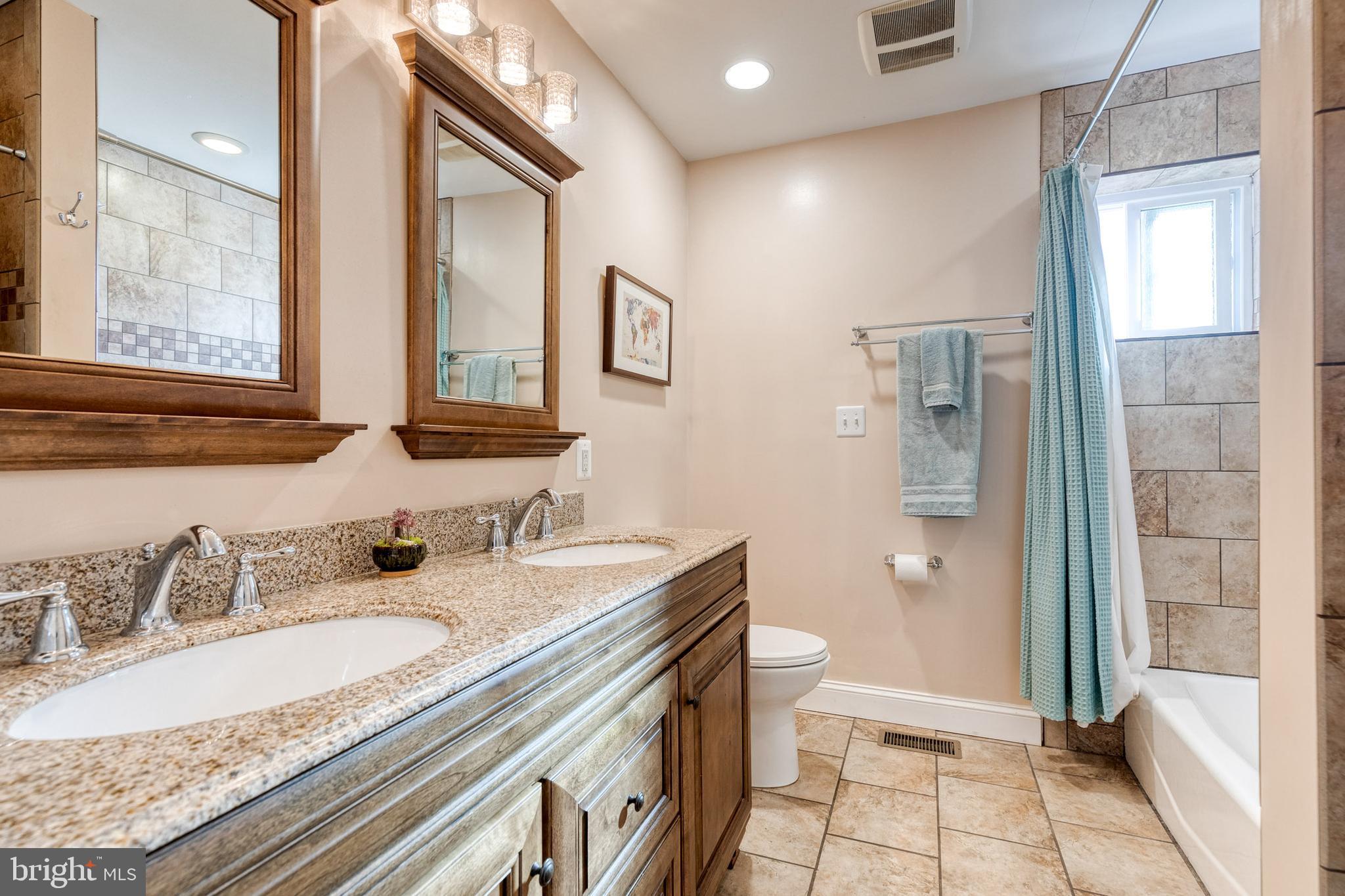 1205 Roland Heights Avenue Baltimore, MD 21211 - Photo 18 of 36 a bathroom with a granite countertop sink mirror and double