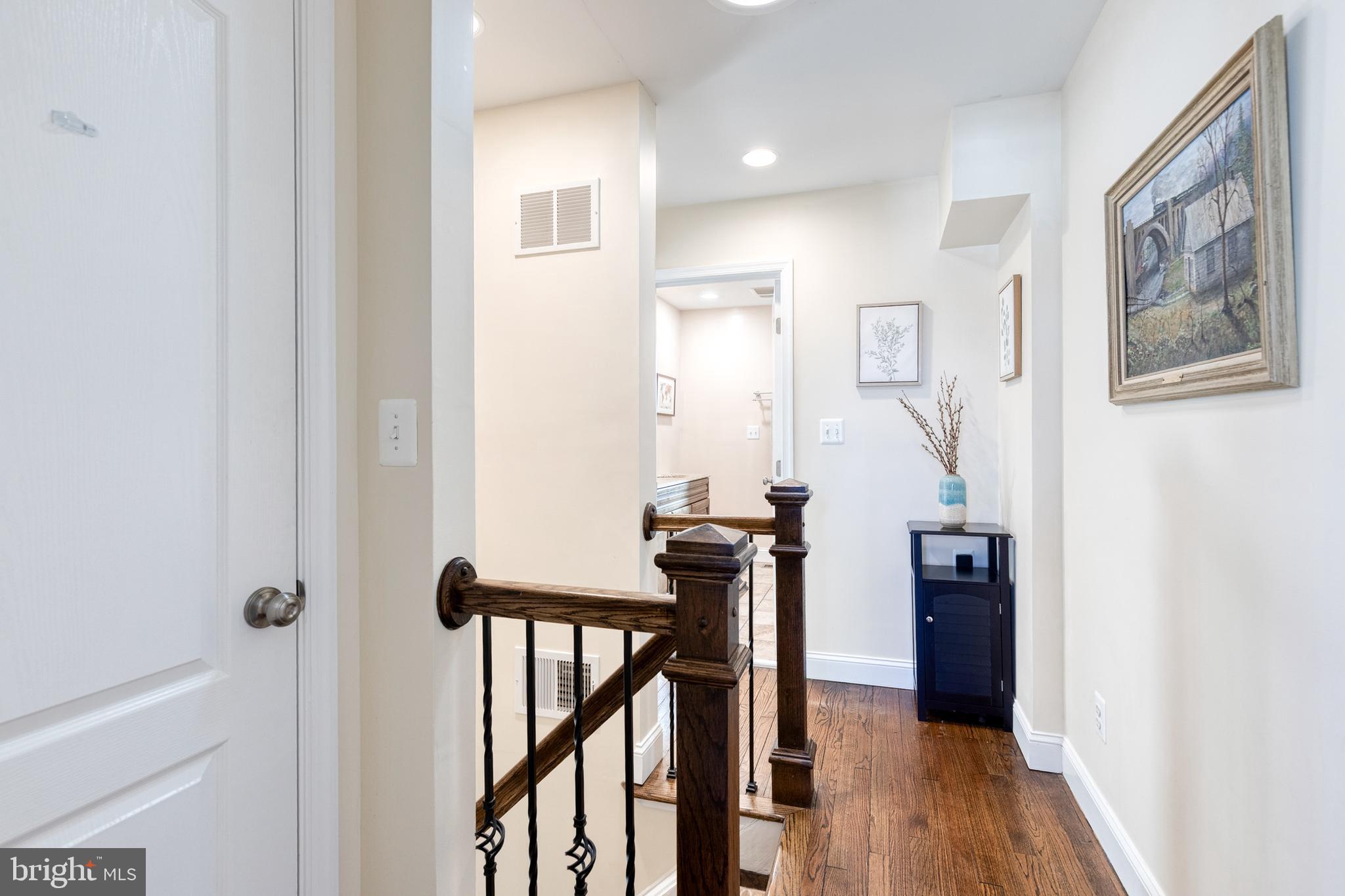 1205 Roland Heights Avenue Baltimore, MD 21211 - Photo 21 of 36 a view of a hallway with wooden floor and staircase