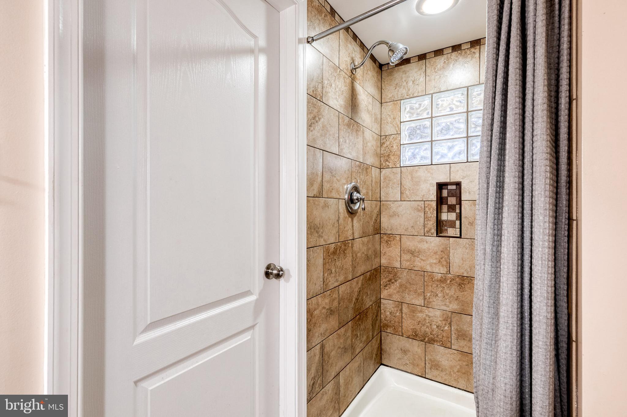1205 Roland Heights Avenue Baltimore, MD 21211 - Photo 26 of 36 a bathroom with a glass shower door