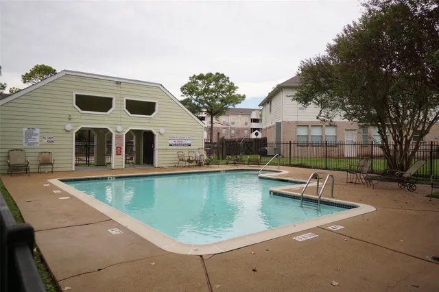 a view of a patio with swimming pool and sitting area