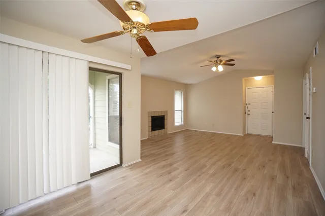 wooden floor in an empty room with a chandelier fan