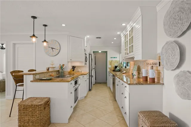a kitchen with stainless steel appliances granite countertop a sink a stove and a wooden floors