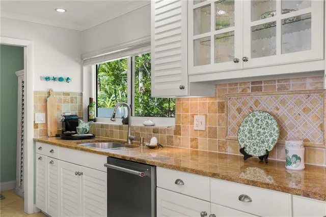 a kitchen with stainless steel appliances granite countertop a sink and a window