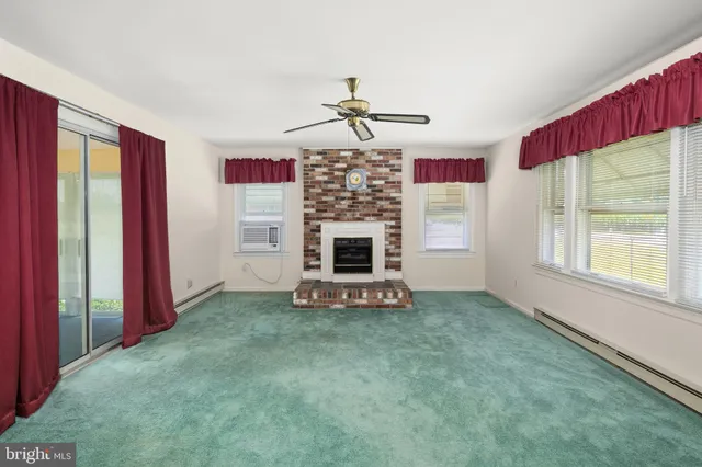 a view of a livingroom with a fireplace and window