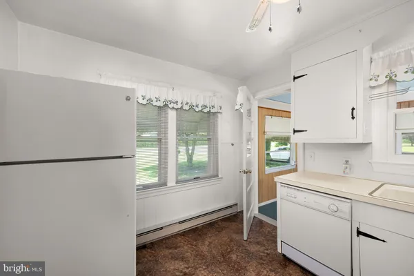 a kitchen with a refrigerator a stove cabinets and wooden floor