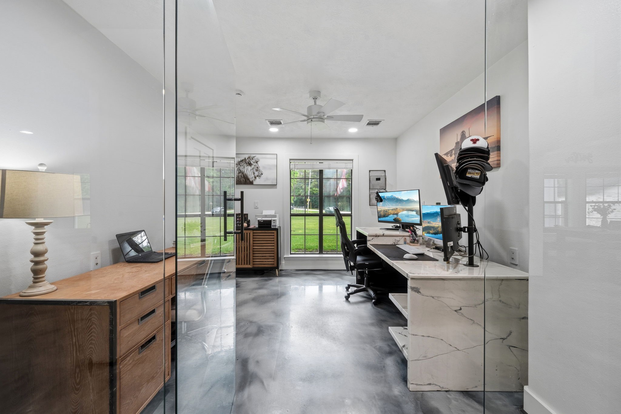 18 East Old Field Road Huffman, TX 77336 - Photo 5 of 35 This stylish home office is gracefully positioned behind sleek frameless glass, creating a refined and sophisticated workspace. Thoughtfully designed with clean modern finishes, the space is enhanced by oversized windows that flood the room with natural light.