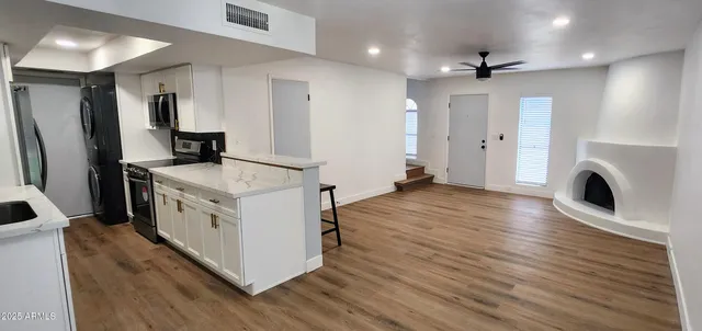 a kitchen with stainless steel appliances granite countertop a wooden cabinets and a wooden floors