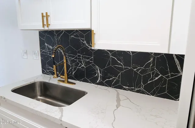 a kitchen with a sink and white cabinets