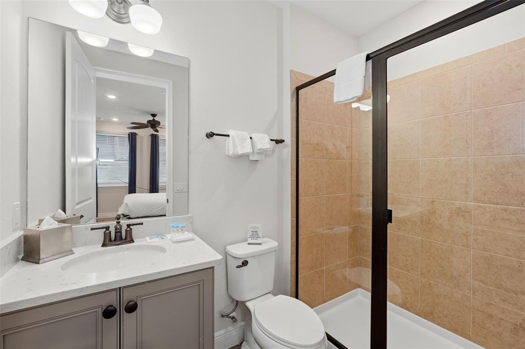 8098 Knee Deep Road Kissimmee, FL 34747 - Photo 30 of 40 a bathroom with a sink a toilet a mirror and shower