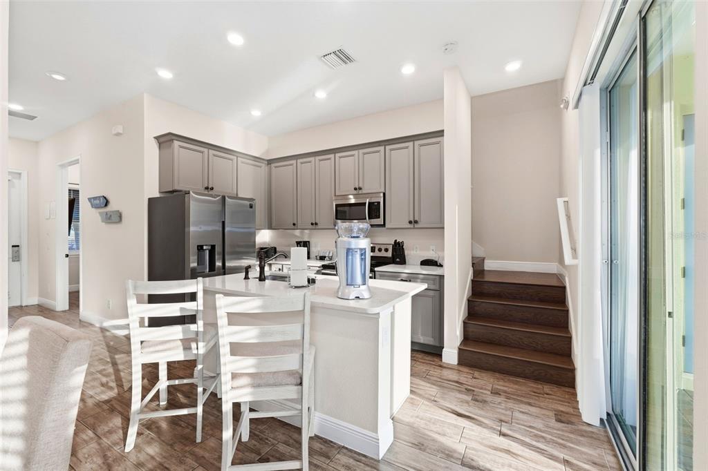 8098 Knee Deep Road Kissimmee, FL 34747 - Photo 8 of 40 a kitchen with stainless steel appliances kitchen island granite countertop a refrigerator and cabinets