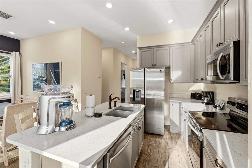 8098 Knee Deep Road Kissimmee, FL 34747 - Photo 9 of 40 a kitchen with stainless steel appliances granite countertop a sink stove refrigerator and a window
