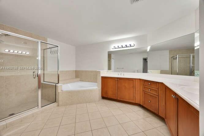 8395 Southwest 73rd Avenue, Unit 104 Miami, FL 33143 - Photo 14 of 35 a spacious bathroom with a granite countertop sink a mirror and a bathtub