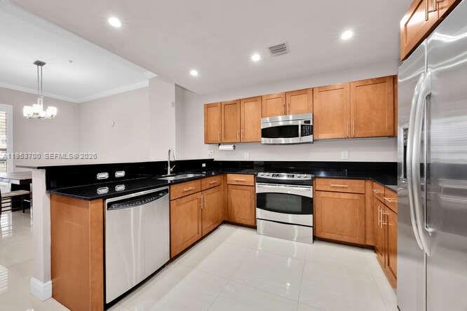 8395 Southwest 73rd Avenue, Unit 104 Miami, FL 33143 - Photo 5 of 35 a kitchen with stainless steel appliances granite countertop a stove and a sink