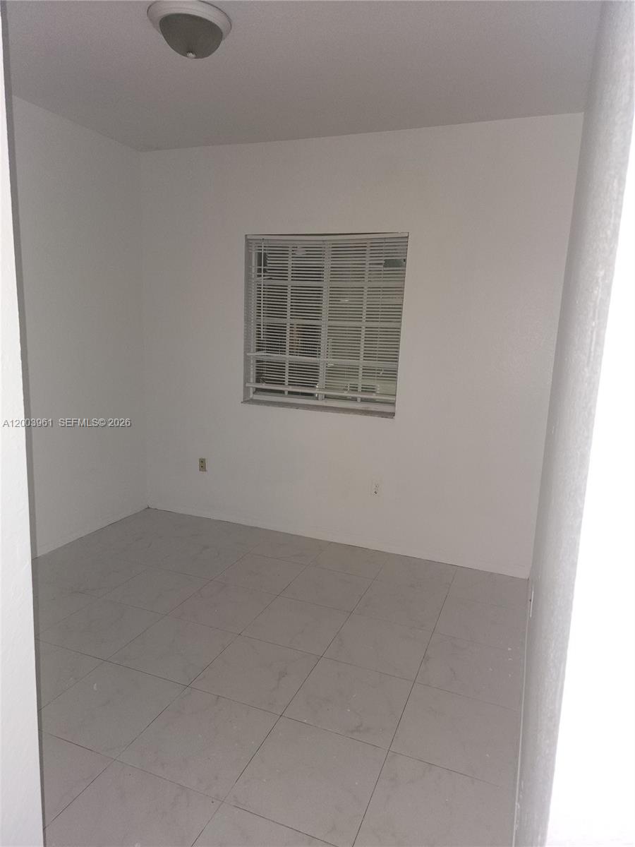 6972 Northwest 179th Street, Unit 2034 Hialeah, FL 33015 - Photo 3 of 10 an empty room with windows