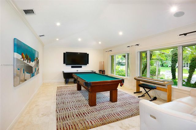a room with pool table and windows