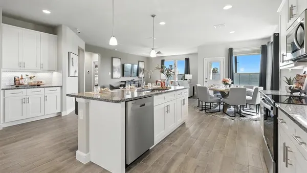 a kitchen with a dining table chairs sink and cabinets