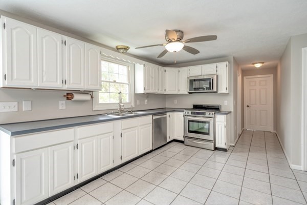 9 Autumn Way Pembroke, MA 02359 - Photo 15 of 42 a kitchen with granite countertop white cabinets white stainless steel appliances with a sink and dishwasher