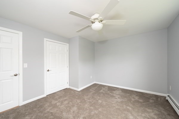 9 Autumn Way Pembroke, MA 02359 - Photo 21 of 42 an empty room with a chandelier fan and windows