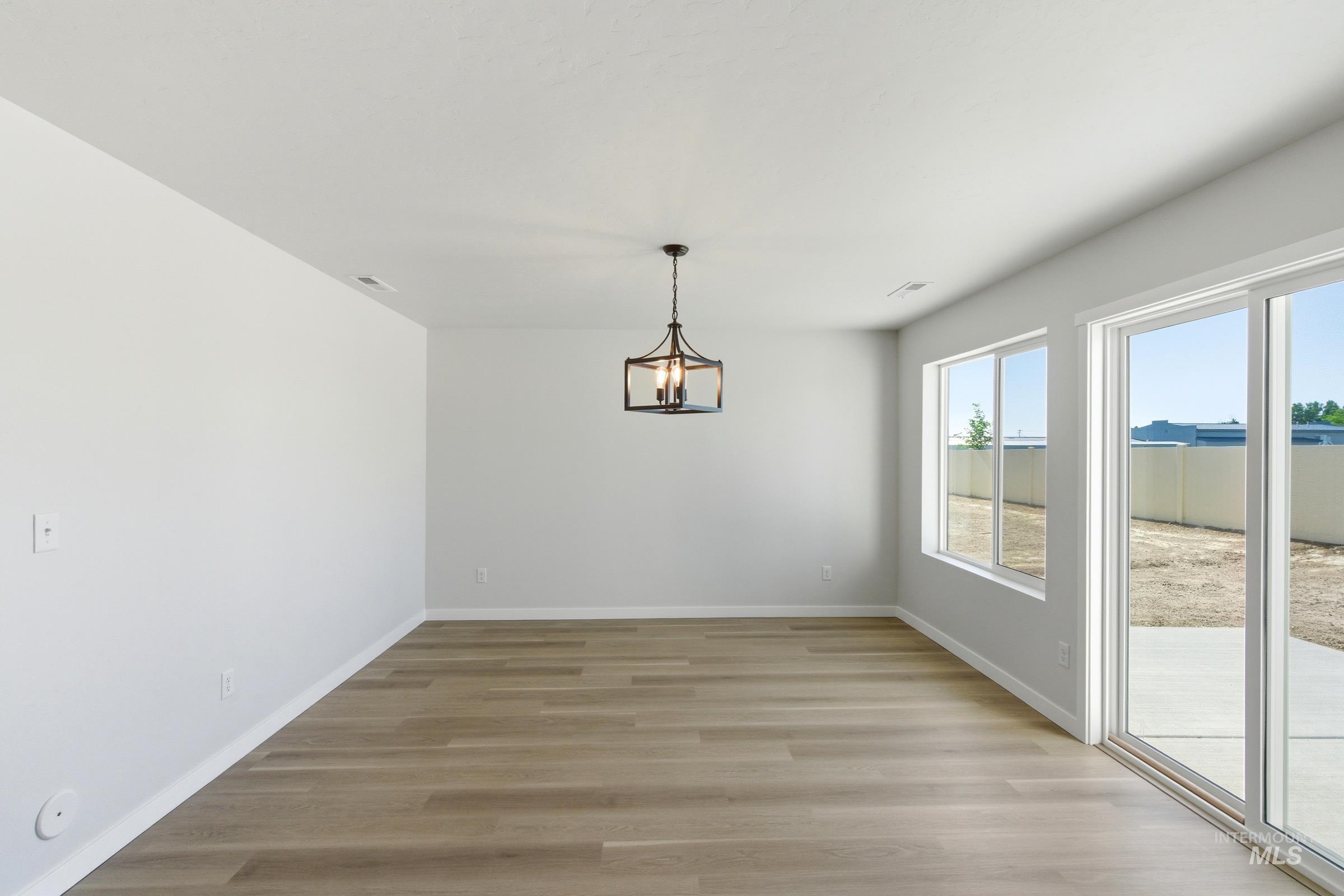 13677 Redway Court Caldwell, ID 83607 - Photo 7 of 35 Open concept living area with light wood-finish flooring