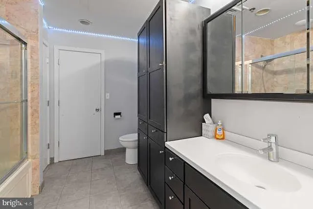a bathroom with a double vanity sink mirror and toilet