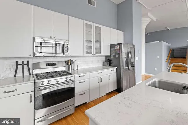 a kitchen with stainless steel appliances a stove a sink and a refrigerator